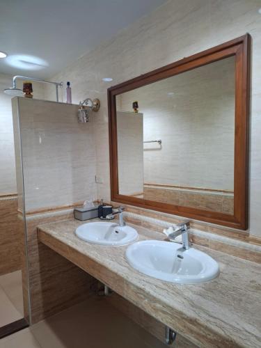 a bathroom with two sinks and a large mirror at Cozy Country House with Pool in Ban Nong Nam Khem