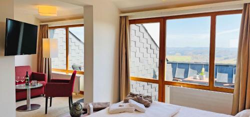 a bedroom with a bed and a table and a window at Bernstein Landhaus Nordhelle in Meinerzhagen