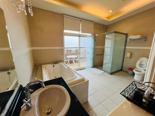 a bathroom with a sink and a tub and a toilet at Huis Ten Bosch in Ren'ai