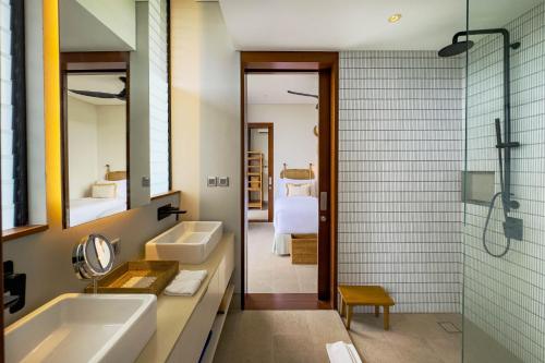 a bathroom with two sinks and a shower at Selong Selo Resort and Villas in Selong Belanak