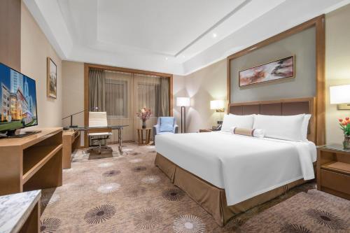a hotel room with a large bed and a desk at Ramada Plaza Pudong Shanghai in Shanghai
