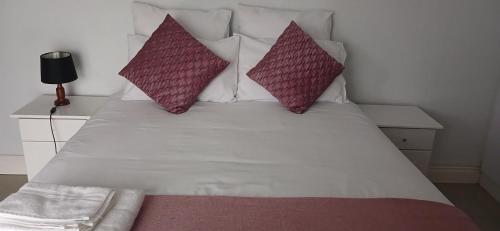 a white bed with two pillows on top of it at Blessing in East London