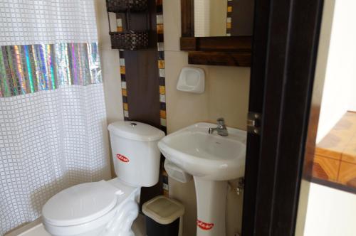 a small bathroom with a toilet and a sink at Playa Aventura Hotel in Ayangue