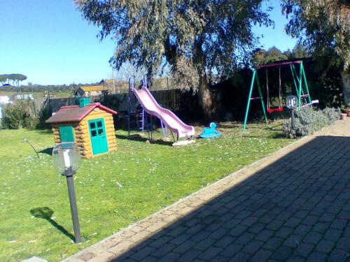 een park met een speeltuin met een glijbaan en een parkeermeter bij B&B RoLu in Prima Porta