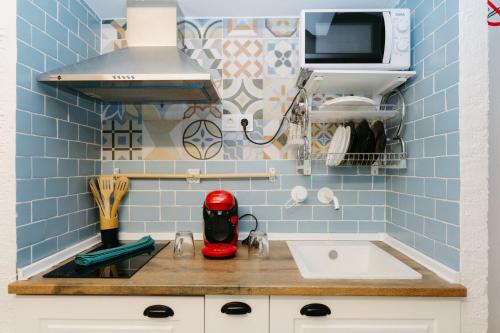 a small kitchen with blue tiles on the wall at Verdejo - Harbor's Light in Villajoyosa