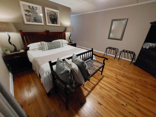 a bedroom with a large bed and a wooden floor at The Ranch House at African Safari Lodge in Grahamstown