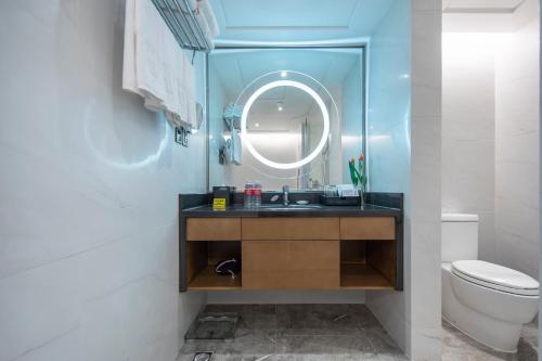 a bathroom with a sink and a mirror and a toilet at Ramada Plaza Pudong Shanghai in Shanghai