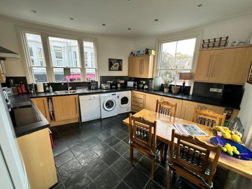 a kitchen with a table and a sink and a dishwasher at Luxury Rooms - St Leonards on Sea - East Sussex in St. Leonards