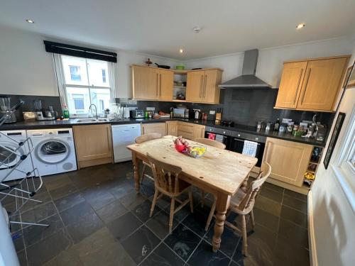 a kitchen with a wooden table with chairs and a sink at Luxury Rooms - St Leonards on Sea - East Sussex in St. Leonards