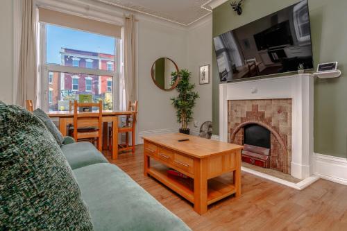a living room with a couch and a fireplace at Stylish city view flat in mural quarter in Bristol