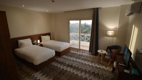 a hotel room with two beds and a balcony at The View Luxor hotel in Luxor