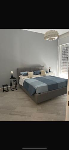 a bedroom with a large bed with blue pillows at Siracusa Vacanze in Syracuse