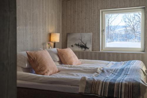 a bedroom with a large bed with a window at Röstavallens Högfjällshotell in Tänndalen