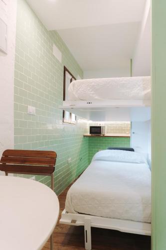 a bedroom with a bed and a green tiled wall at Cabernet Sauvignon - Harbor's Light in Villajoyosa