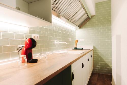 a kitchen with a sink and a red appliance on a counter at Cabernet Sauvignon - Harbor's Light in Villajoyosa