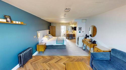 a bedroom with a bed and a blue wall at St George's Hotel - Llandudno in Llandudno