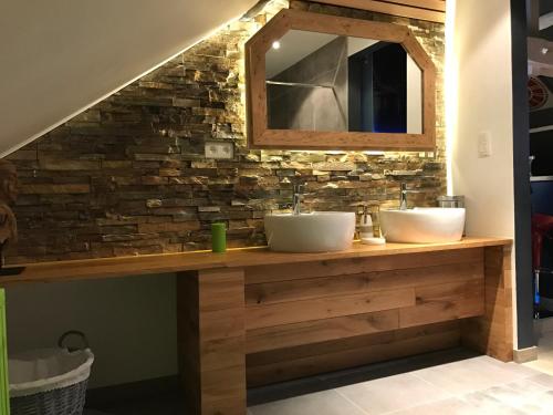 ein Badezimmer mit 2 Waschbecken und einer Steinmauer in der Unterkunft La Suite Diamant in Theux