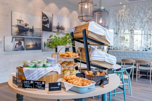 a table with a display of pastries and other food at Motel One Rostock in Rostock