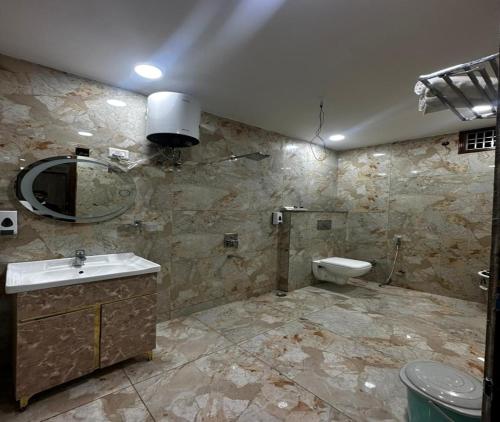 a bathroom with a sink and a toilet at Minta Hotel and Banquet in Noida