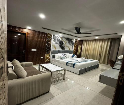 a living room with a bed and a couch at Minta Hotel and Banquet in Noida