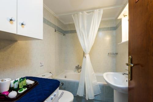 a bathroom with a toilet and a sink and a tub at Eleonas Apartments in Prinés