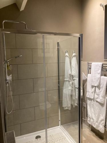 a shower with a glass door and towels in a bathroom at Maplestone in Shepton Mallet