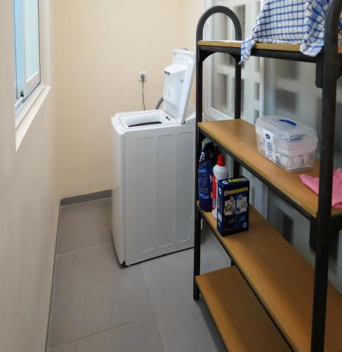 a small washing machine in a room with a shelf at 2 bedroom apartment in Atlit, Haifa district in Atlit