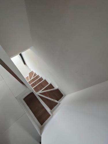 a staircase in the ceiling of a white room at Park Serpong Type XYZ Cluster Charm in Carangpulang