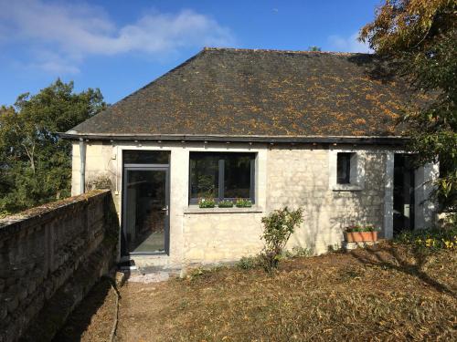 a small white brick house with a window at Belle vue in Montsoreau