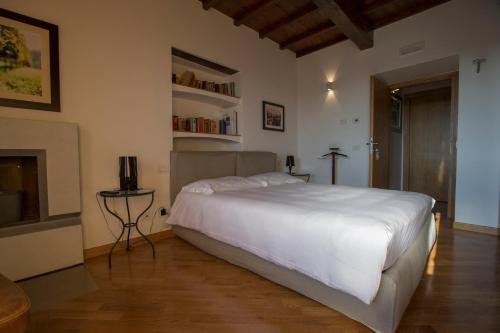 a bedroom with a large white bed and a table at Palazzo Tronconi agriturismo in Arce