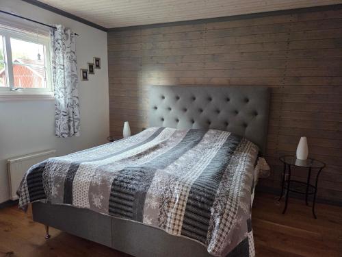 a bedroom with a bed with a blanket and a window at B & B Flattinge Fritidshus in Vittaryd