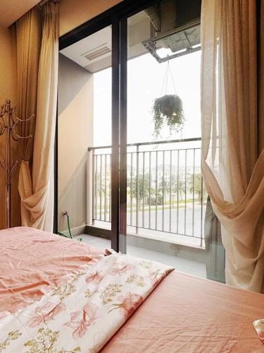 a bedroom with a bed and a window with a balcony at Studio Ocean Park 0301 - toà S1 in Gia Lâm Pho