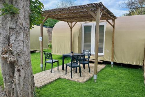 a table and chairs on a deck in front of a yurt at Paris Camping Ile du Roi in Triel-sur-Seine
