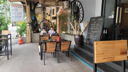 a group of people sitting at a table outside a restaurant at Park Inn Boutique and Hostel in Kampot