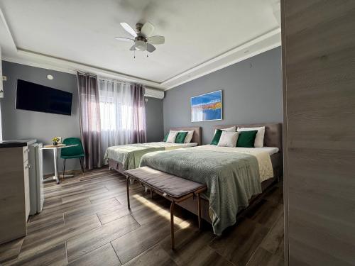 a hotel room with two beds and a ceiling fan at Villa Sun Budva in Budva