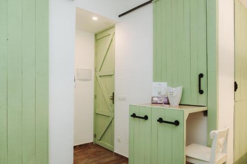 a room with green doors and a desk with a chair at Prieto Picudo - Harbor's Light in Villajoyosa