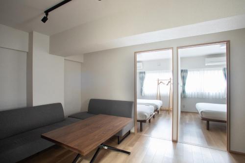 a room with a couch and a table and a mirror at NIYS apartments 01 type in Tokyo