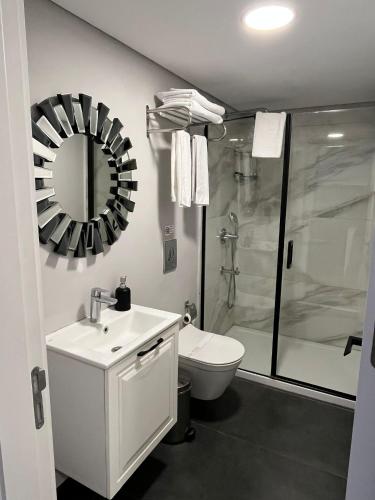 a bathroom with a shower and a toilet and a mirror at Myway Deluxe Hotel in Konak