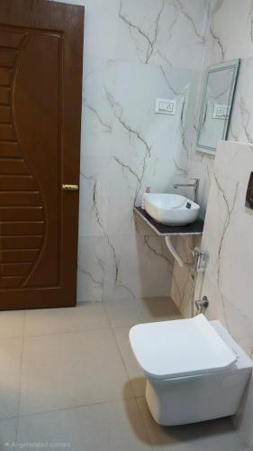 a bathroom with a toilet and a sink at Bellevue Retreat in Alībāg