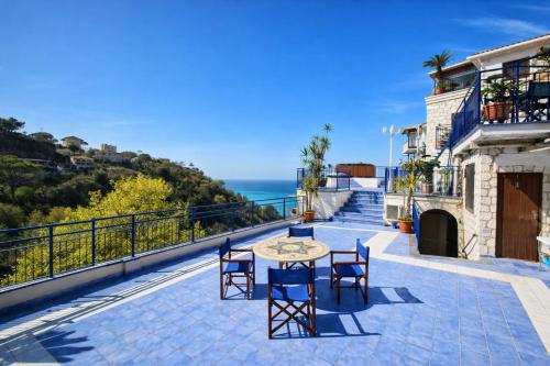 a patio with a table and chairs overlooking the ocean at Hotiday Vico Equense in Vico Equense