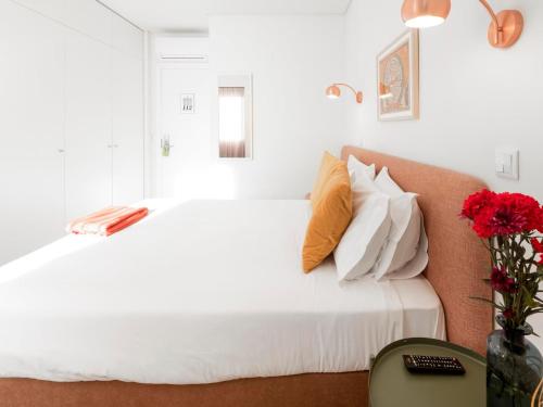 a bedroom with a large white bed with orange pillows at LSA Restauradores by Numa in Lisbon