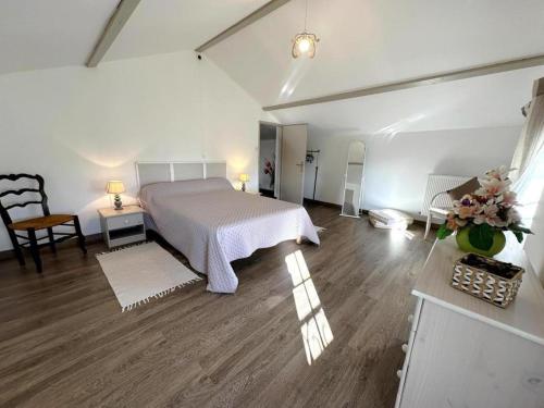 a large white bedroom with a bed and a table at Maison jeanborde in Serreslous-et-Arribans