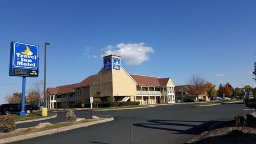 a building with a sign in the middle of a street at Travel Inn Motel in Hartford
