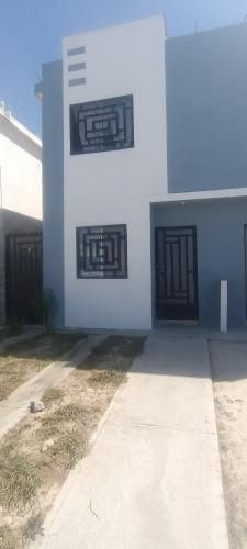 a white building with black doors and a sidewalk at Paseo San Andres in Zacatecas