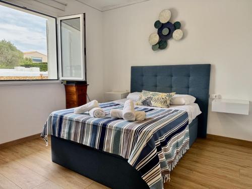 a bedroom with a blue bed with towels on it at Villa Coral in Cala en Blanes