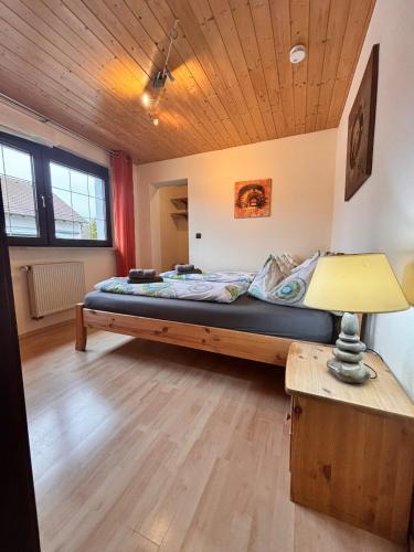 a large bed in a room with a wooden ceiling at Ferienwohnung Buronia 2 in Kaufbeuren