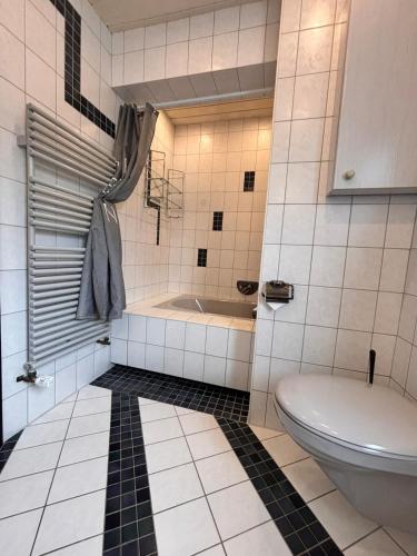 a bathroom with a toilet and a bath tub at Ferienwohnung Buronia 2 in Kaufbeuren