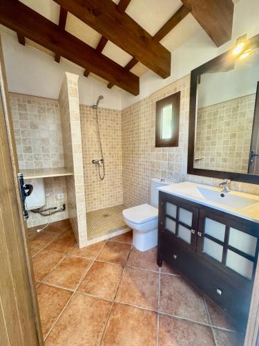 a bathroom with a toilet and a shower and a sink at Villa Coral in Cala en Blanes