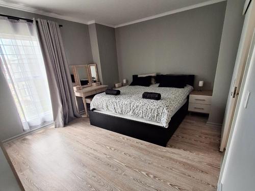 a bedroom with a bed and a large window at Merve's Place - Portobelo 48 in Mossel Bay