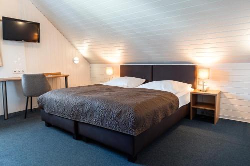 a bedroom with a bed and a desk and a chair at Römerhof in Stuttgart